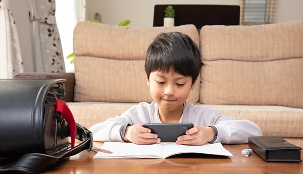 スマートフォンでオンラインカレッジを使う男の子